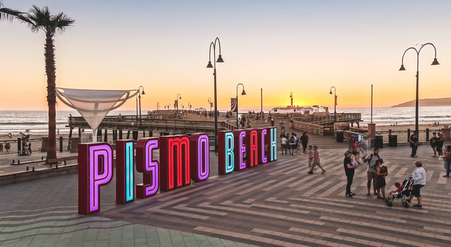 Pismo Beach sign beside the pier at sunset